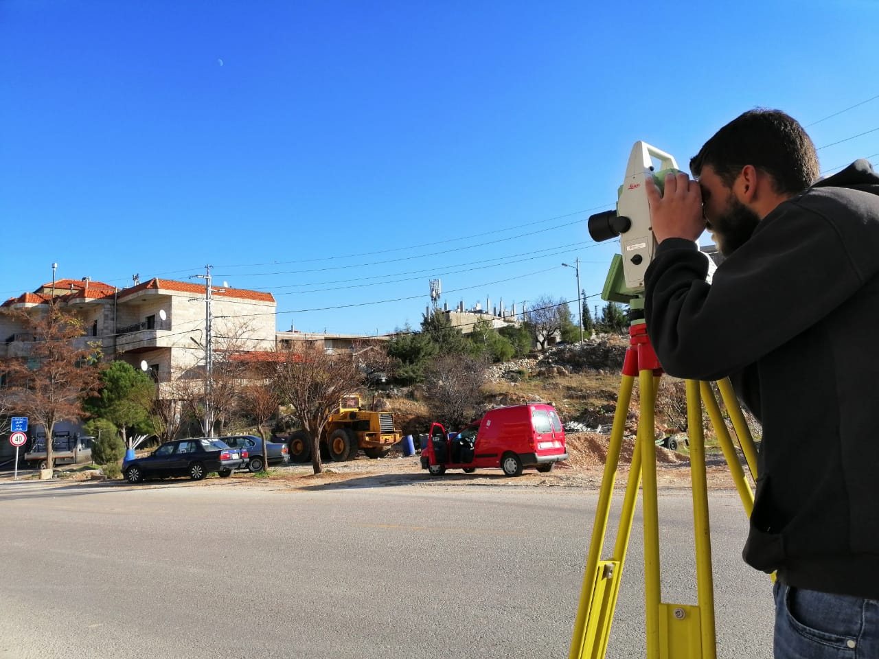 Surveying professional operating a total station in the field